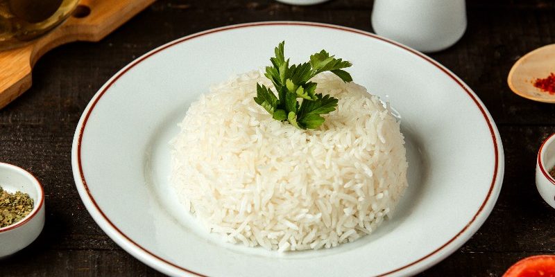 side view of a plate with cooked rice with parsley on the table