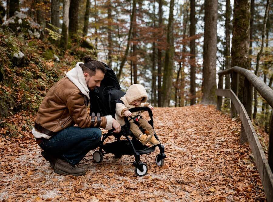padre e bambino nel passeggino facendo una passeggiata in autunno